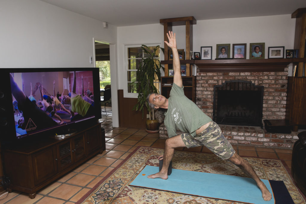 Bryan Kest doing a yoga pose in a living room.